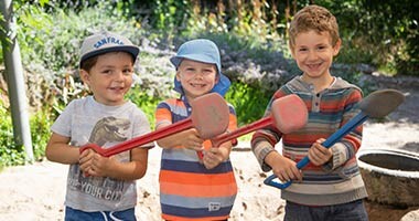 Drei Kinder spielen draußen.