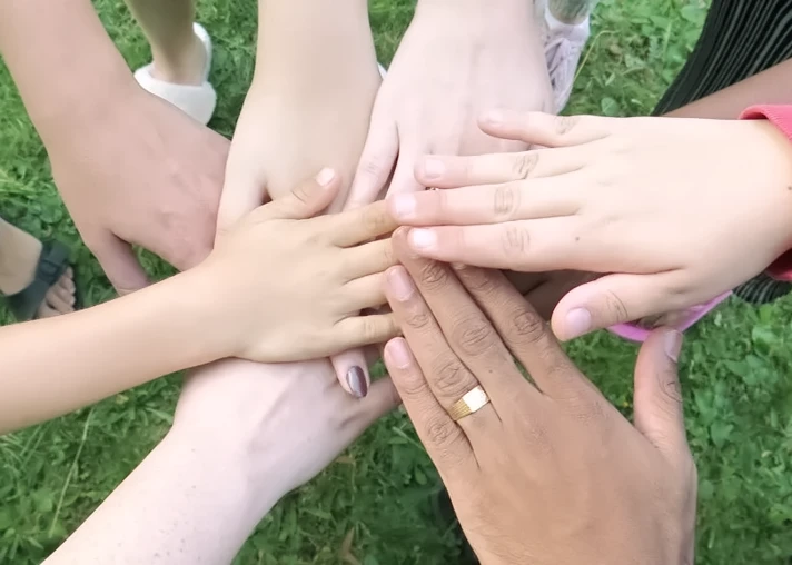 Hände von vier Menschen berühren sich