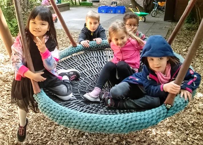 Kinder in einer Vogelnestschaukel